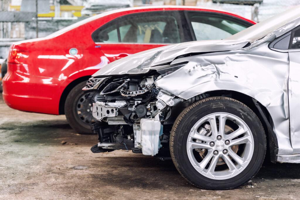 Many wrecked car after traffic accident crash at restore service maintenance station garage indoor. Insurance salvage vehicle auction wholesale storage. Auto body wreck damage work workshop center